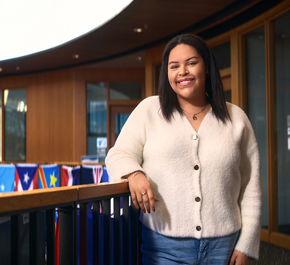 امرأة تقف بذراعين متقاطعتين بجانب نافذة